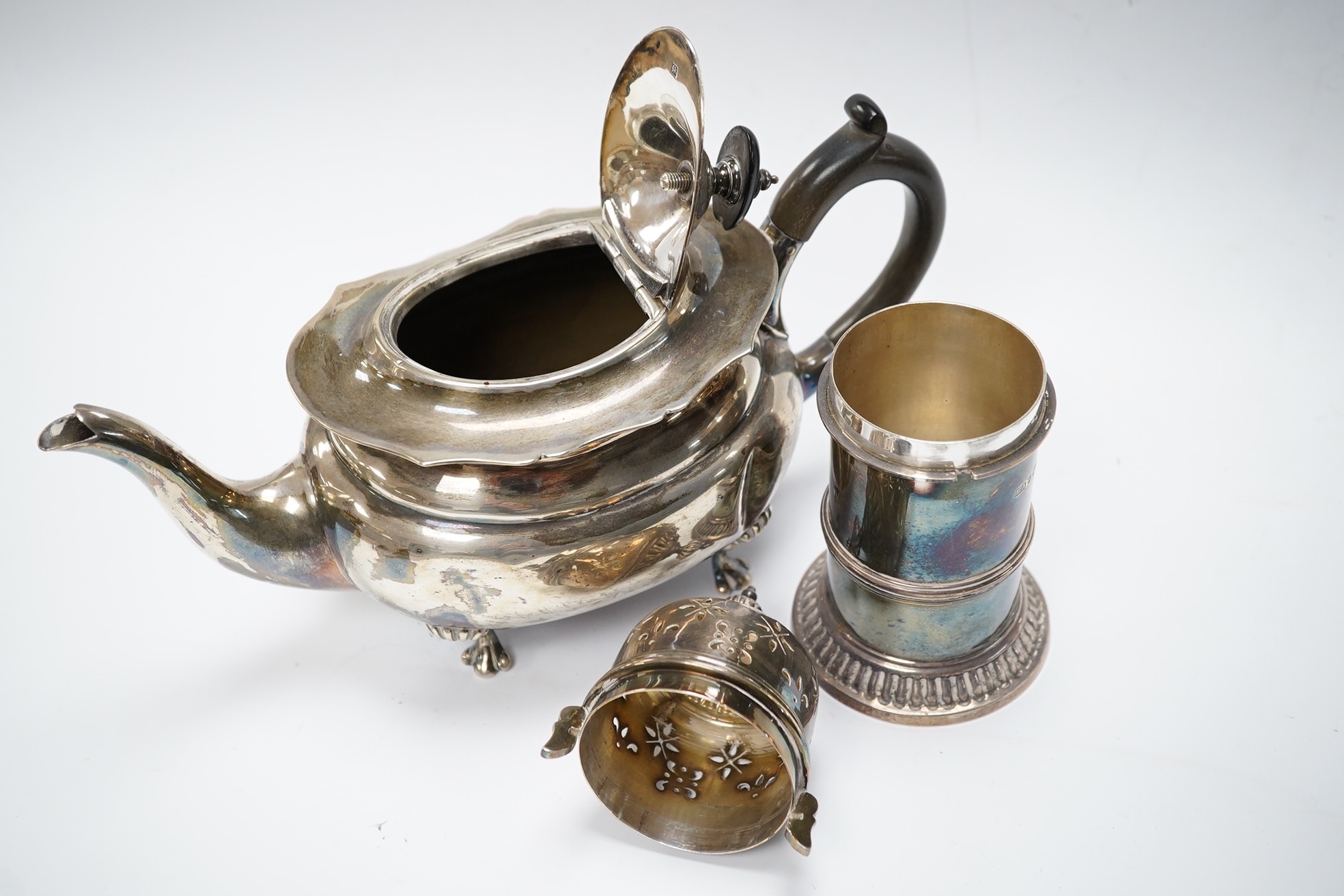 An Edwardian bachelor's silver teapot, Henry Wigful?, Sheffield, 1903, together with a George V silver lighthouse sugar caster by Atkin Brothers, 15.4cm, gross weight 19.5oz. Condition - poor to fair